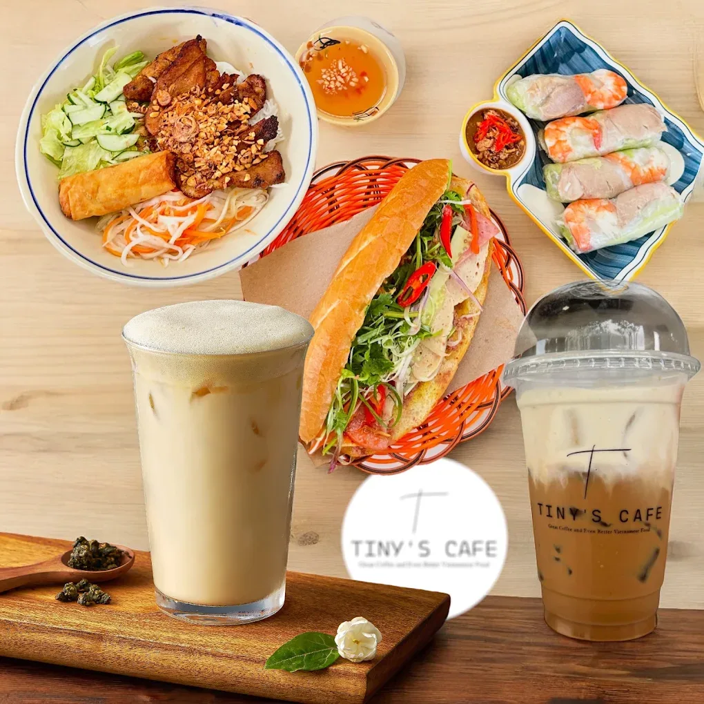 Bánh mì, spring rolls, grilled pork vermicelli and Tiny's Cafe salted coffee laid out on a wooden table